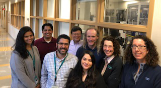 group of smiling people in a hallway at Merck